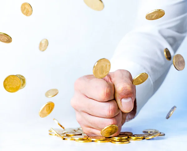 anti-corruption concept. man\'s fist hits the table and gold coins levitation. willpower versus wealth.