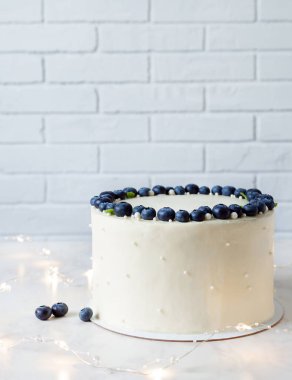 Yaban mersininden yapılmış çelenkli beyaz pasta ve çelenkli nane şekeri.