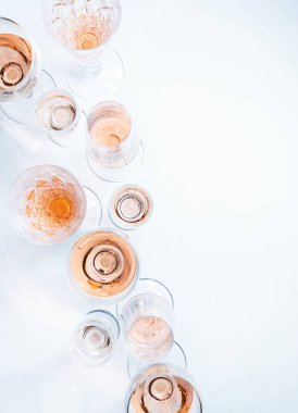Farklı bardaklarda köpüklü gül şarabı beyaz arka planda fotokopi alanı ile