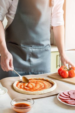 Pizza hamuruna domates sosu sür..