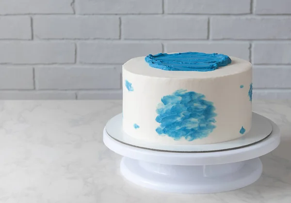 Pastel blanco simple con decoración azul en la mesa — Foto de Stock