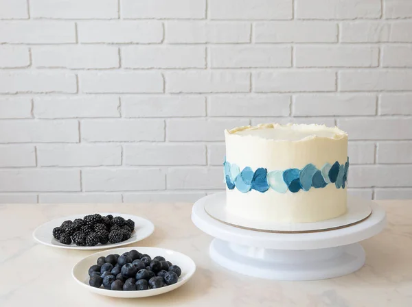Pastel blanco con trazos azules crema y arándanos y moras para la decoración — Foto de Stock