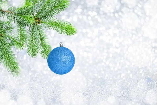 Vánoce věčně zelený smrk strom a modrý míč na šedém lesklém pozadí s bokeh — Stock fotografie