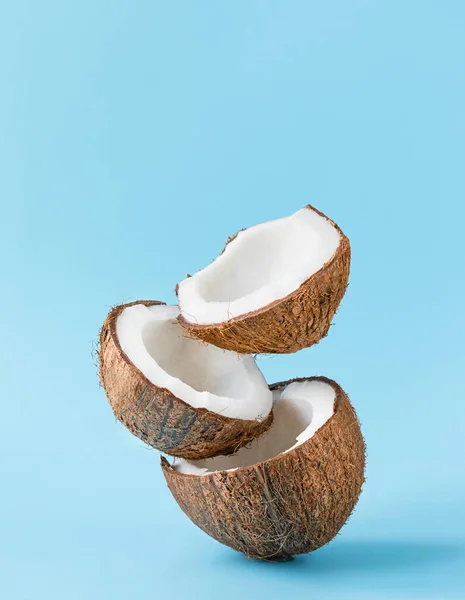 Gebarsten kokosnoten op blauwe achtergrond. verticaal. kopieerruimte — Stockfoto