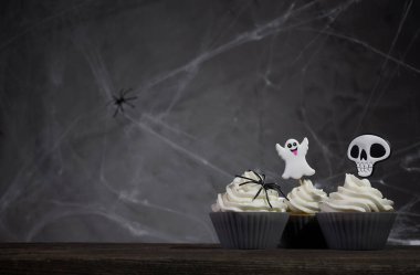 Karanlık bir arka planda örümcek ağlı korkutucu cadılar bayramı kekleri..