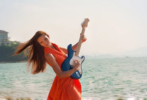 Girl with a guitar on the beach