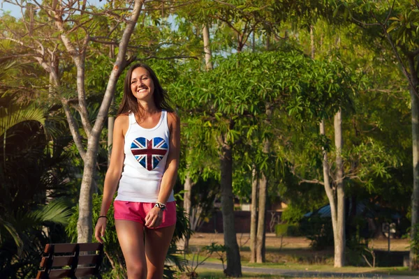 Mooie jonge vrouw lopen in een park. Zomertijd — Stockfoto