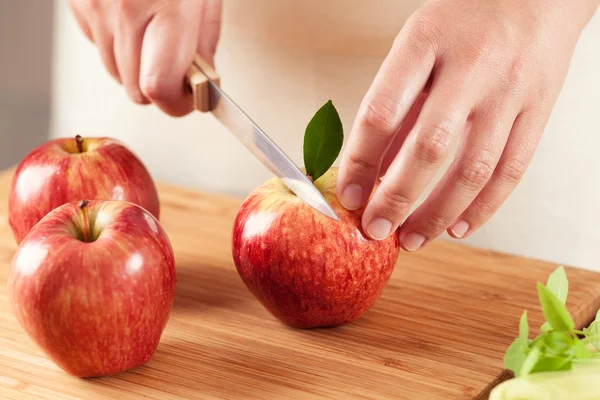 Frau schneidet einen Apfel — Stockfoto