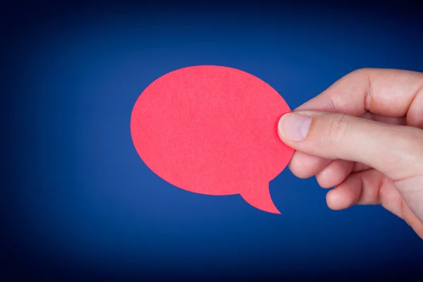 Woman hand holding red speech bubble — Stock Photo, Image