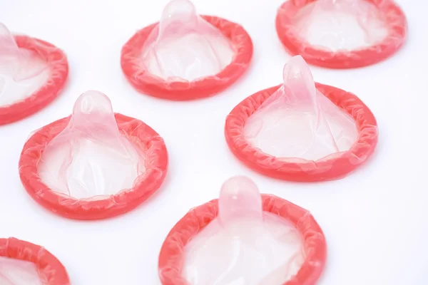 Red condoms on a white background — Stock Photo, Image