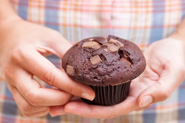 Kadın çift çikolatalı muffin onun elinde tutar. — Stok fotoğraf