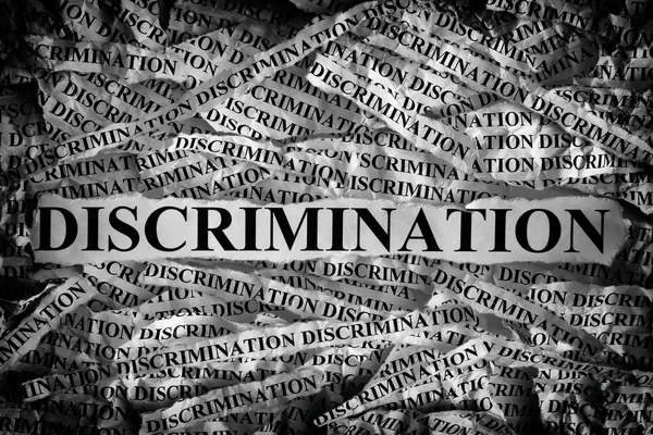 Pedaços de papel rasgados com a palavra discriminação — Fotografia de Stock