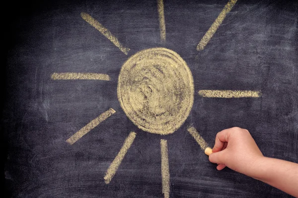 Child drawing sun with chalk — Stock Photo, Image