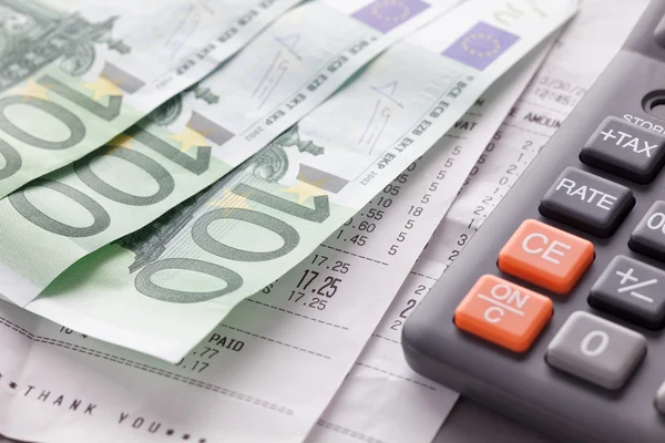 Calculadora con billetes y recibos en euros —  Fotos de Stock
