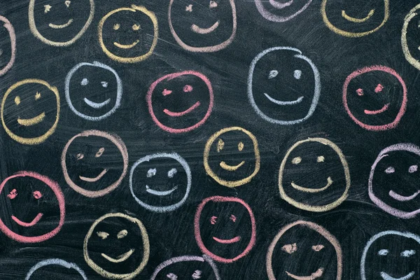 Bunte Smileys auf Kreidetafel Hintergrund — Stockfoto