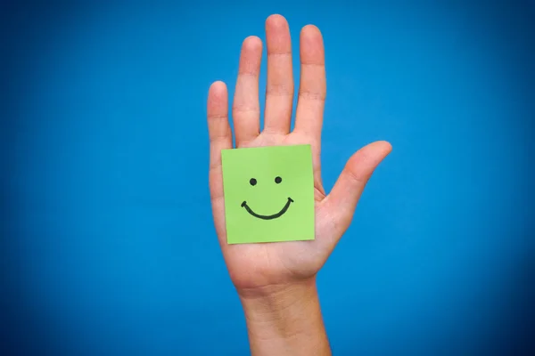 Green paper note with smile in woman palm — Stock Photo, Image