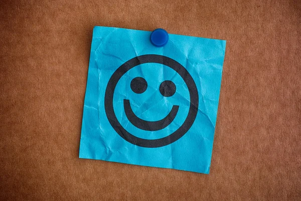 Nota de papel azul com rosto feliz — Fotografia de Stock