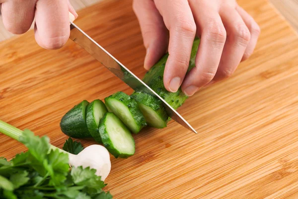 Woman cutting cucumber — Stock Photo, Image