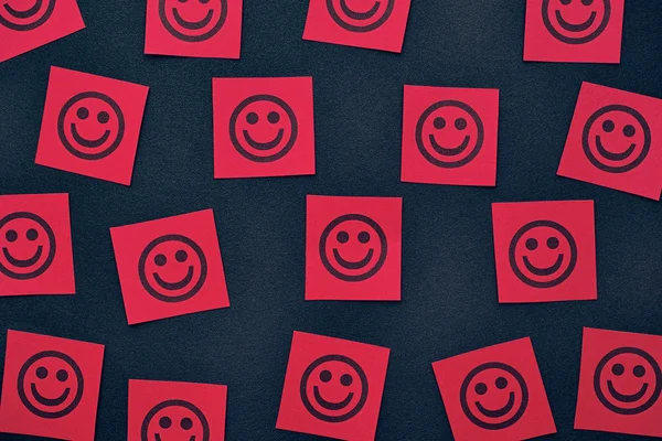 Červený papír poznámky s šťastné tváře — Stock fotografie