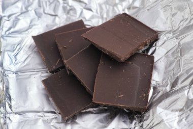 Koyu çikolata parçacıkları folyonun üzerinde. Kapat..