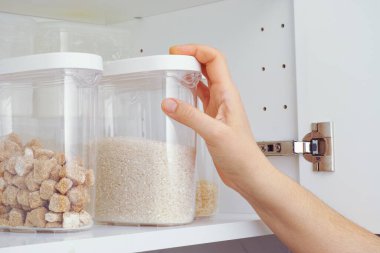 Mutfak dolabından pirinç alan bir kadın. Kapat..