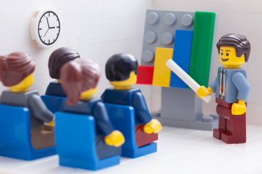 Tambov, Rusya Federasyonu - 26 Şubat 2021 Lego iş adamları minifigürler toplantı yapıyorlar ve başarılı takım çalışmalarının sonuçlarını gösteren grafikleri tartışıyorlar.