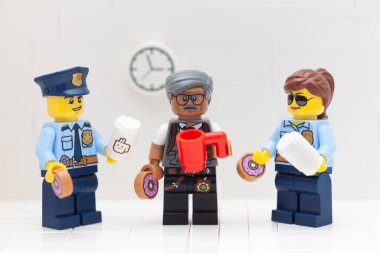 Tambov, Rusya Federasyonu - 17 Mart 2021 Lego polisi, kadın polis ve emniyet müdürü minyatürleri kahve içip polis ofislerinde donut yiyorlar.