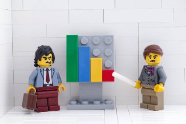 Tambov, Rusya Federasyonu - 28 Mayıs 2021 Lego iş adamları minifigürler toplantı yapıyorlar ve başarısız takım çalışmalarının sonuçlarını gösteren grafikleri tartışıyorlar.
