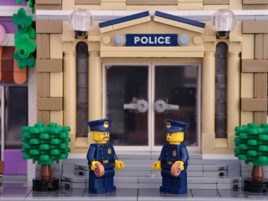 Tambov, Rusya Federasyonu - 2 Temmuz 2021 İki Lego polisi polis merkezinin önünde durup donut yiyor..