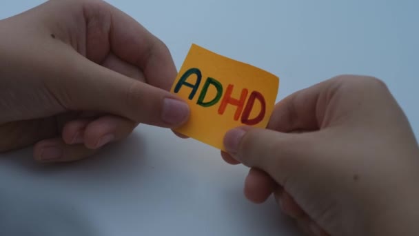 Elinde Sarı Kağıt Bir Tutan Bir Çocuk Üzerinde Adhd Kısaltması — Stok video