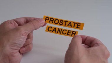 Elinde Prostat Kanseri yazan sarı kağıt parçaları tutan bir adam. Kapat..