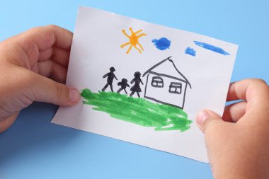 Çocuk çizilmiş bir ev aile ile tutar.