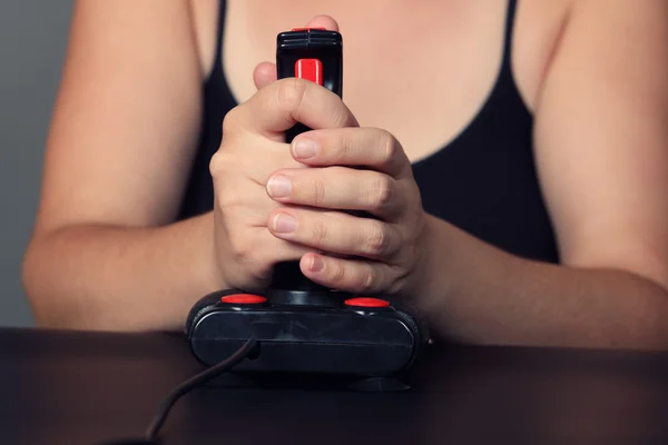 Молодая женщина играет в видеоигры с ретро-джойстиком — стоковое фото
