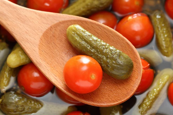 Eingelegte Tomaten und Gurken in einem Holzlöffel — Stockfoto