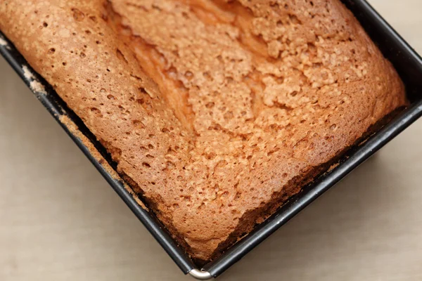 Freshly baked bread in a loaf tin — Stock Photo, Image