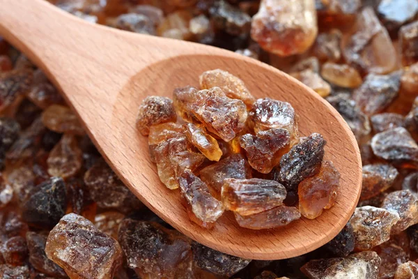 Rock cane sugar on a wooden spoon — Stock Photo, Image