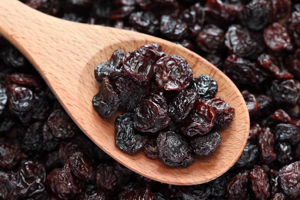 Raisins in a wooden spoon — Stock Photo, Image