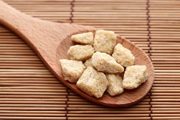 Brown cane sugar in a wooden spoon — Stock Photo, Image