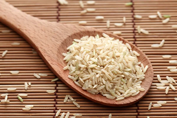 Arroz integral en una cuchara de madera —  Fotos de Stock