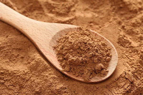 Cocoa powder in a wooden spoon — Stock Photo, Image