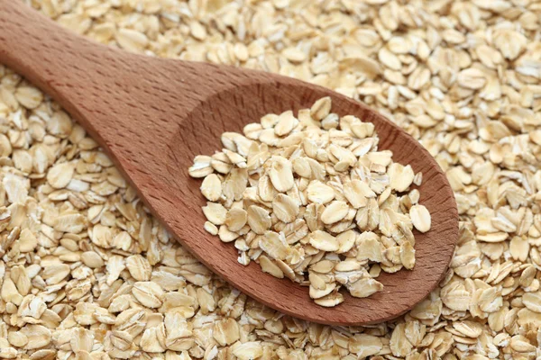 Rolled oats in a wooden spoon — Stock Photo, Image