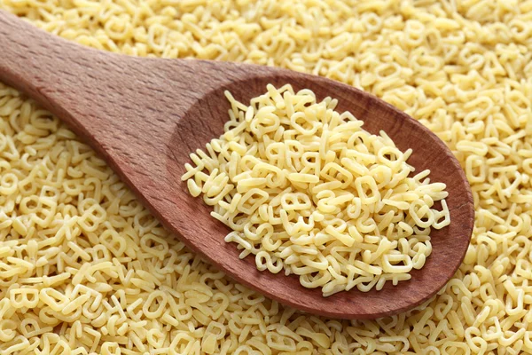 RAW alfabetet soppa pasta i en träsked — Stockfoto