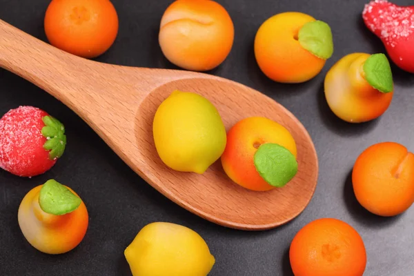 Marzipan fruit shapes in a wooden spoon — Stock Photo, Image