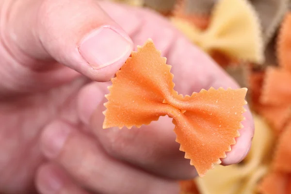 Pasta farfalle in the fingers — Stock Photo, Image