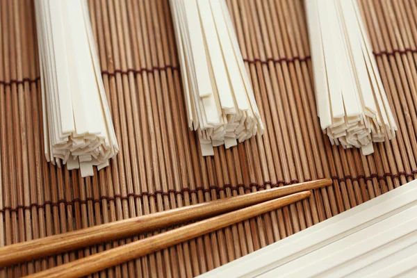 Udon noodles and chopsticks on bamboo napkin — Stock Photo, Image