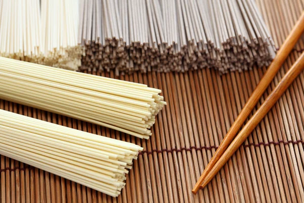 Fideos japoneses con palillos en servilleta de bambú —  Fotos de Stock