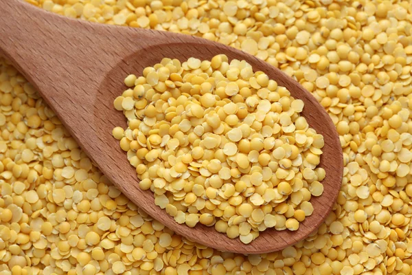 Yellow lentils in a wooden spoon — Stock Photo, Image