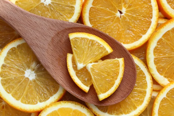 Orange slices in a wooden spoon — Stock Photo, Image