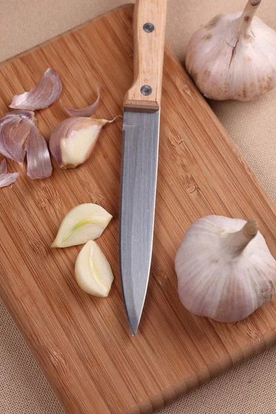 Ajo y cuchillo en tabla de cortar —  Fotos de Stock