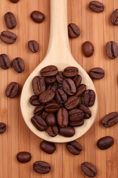 Grains de café dans une cuillère en bois — Photo